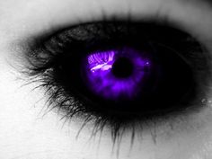 an eye with purple light reflected in it's irise, and the iris is dark