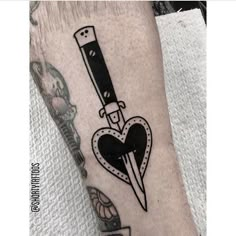 a black and white tattoo with a knife in the shape of a heart