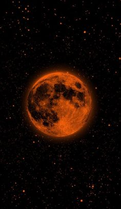 an orange moon is seen in the dark sky