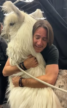 a man hugging an animal on a rope