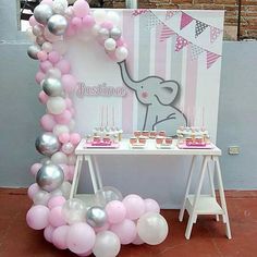 an elephant themed birthday party with balloons and desserts on a table in front of a backdrop