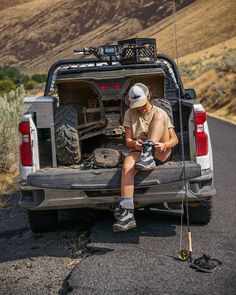 a man sitting in the back of a pick up truck