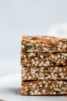 three pieces of granola bars stacked on top of each other with nuts and seeds