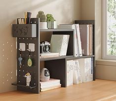 a bookshelf with various items on it in a room next to a window