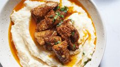 a plate with mashed potatoes, meat and gravy