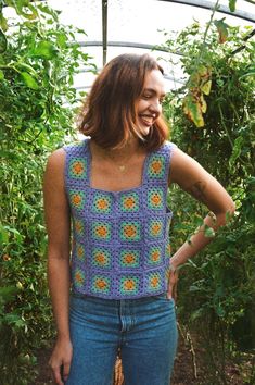 a woman standing in front of some plants