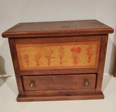 an old wooden box with flowers painted on the front and side drawers in different colors