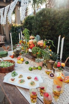 the table is set with food and drinks for an outdoor dinner party or brunch