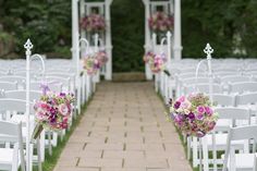 an outdoor wedding ceremony with white chairs and pink bouquets on the back of them