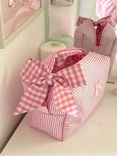 a pink and white checkered bag sitting on top of a counter next to a mirror