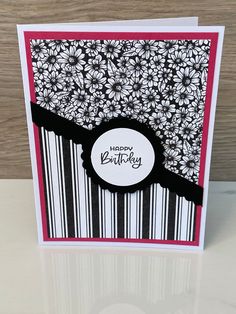 a birthday card with black and white flowers on the front, and pink trimmings