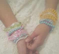 two hands holding each other with bracelets on their wrists and beaded wristbands