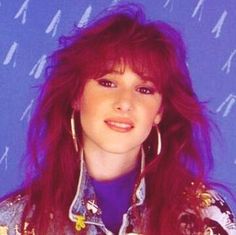 a woman with long red hair is posing for the camera