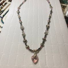 This necklace is a blend of silver alloy hearts, flowers and butterflies mixed with silver and pink crystal beads. The centerpiece, a beautifully polished heart-shaped pink crystal pendant, that radiates an array of colors that dance in the light. Each bead and charm is meticulously arranged to create not just a piece of jewelry but a work of art that graces the neckline. Materials: Silver butterfly, flower and heart beads Heart-shaped gemstone pendant Dimensions: Necklace Length: 18 inches Pendant Size: 1 inch Lobster clasp Pink Heart-shaped Jewelry With Sparkling Stones, Elegant Pink Heart Necklace With Heart Beads, Elegant Silver Beaded Necklace With Heart Charm, Pink Heart Beads Pendant Necklace, Heart-shaped Crystal Beaded Jewelry, Pink Heart Pendant Necklace For Jewelry Making, Pink Heart Pendant Beaded Necklace For Valentine's Day, Pink Crystal Heart Pendant Necklace, Pink Crystal Heart Pendant Jewelry