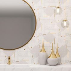 a bathroom with a round mirror and two vases on the counter next to it