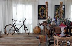 a bicycle is parked in the corner of a room with several pieces of art on display