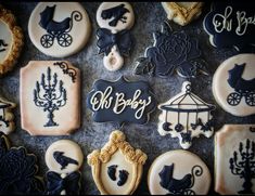 decorated cookies with black and white icing are arranged on a gray tablecloth that says, oh baby