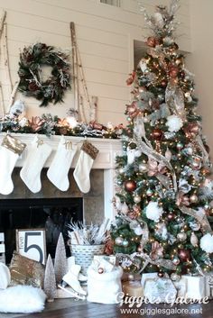 a decorated christmas tree with stockings hanging from it's sides in front of a fireplace