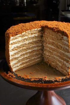 a cake that has been cut in half on a wooden stand with one slice taken out