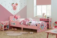 a child's bedroom decorated in pink and white with minnie mouse decorations on the walls