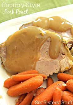 a white plate topped with meat and carrots covered in gravy