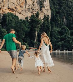 a family walking on the beach holding hands