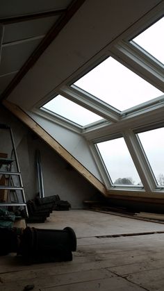 an attic with several windows and tools on the floor