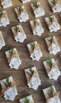 small packages tied with twine and decorated with greenery are arranged on a wooden table