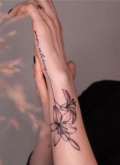 a woman's arm with a flower tattoo on the left side of her hand