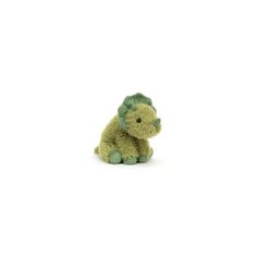 a green stuffed animal sitting on top of a white floor