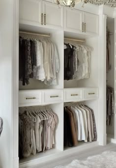 an organized closet with clothes hanging on the doors and drawers, along with a chandelier