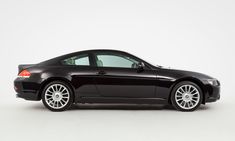 a black sports car parked in front of a white background