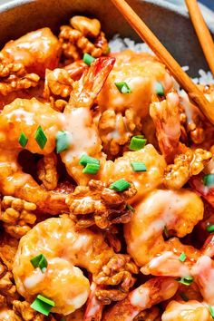 a bowl filled with shrimp and rice next to chopsticks