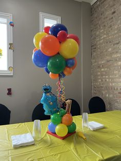 a table topped with balloons in the shape of sesame street characters on top of it