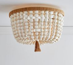 a white wood bead chandelier hanging from the ceiling in a room with an instagram