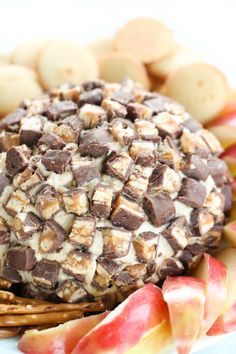 an apple pie with chocolate and caramel on top, sitting next to some crackers