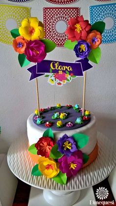 a cake decorated with flowers on top of a white plate and banner in the background