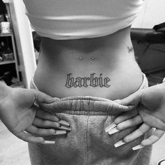 a woman's stomach with the word charlotte tattooed on her lower side ribcage