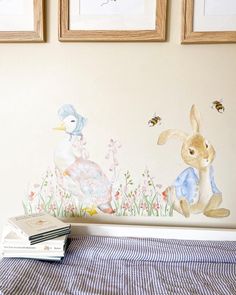 a bed with two pictures on the wall above it and a bunny sitting in front of them