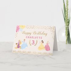 a happy birthday card with princess characters on it next to a vase of yellow flowers