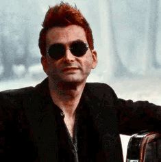 a man with red hair and sunglasses sitting down