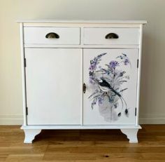 a white cabinet with flowers painted on it