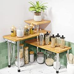 two wooden shelves holding jars and spices in front of a window next to a potted plant