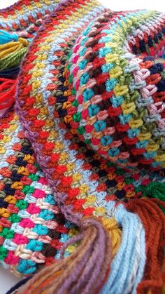 multicolored crocheted blanket laying on top of each other