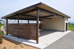 an outdoor shelter with wooden slats on the sides and metal railings at the top