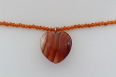 NEW NATURAL  CARNELIAN  HEART   (approx size 16mm) &  NATURAL CARNELIAN BEADS ADJUSTABLE 12.5 - 15.5  INCH   FINDINGS ARE STERLING SILVER 925  THIS IS A PERFECT CHOKER MADE WITH NATURAL STONES COOL & TRENDY IMPERFECTIONS WILL OCCUR DUE TO NATURAL FORMATION FASH SHIPPING FROM NEW YORK CITY +GIFT BOX  #21 Carnelian Heart Gemstone Jewelry, Hand-strung Orange Carnelian Beaded Necklaces, Hand-strung Orange Carnelian Necklaces, Round Orange Carnelian Beads, Trendy Chokers, Delicate Choker, Heart Choker, Artisan Orange Carnelian Beads, Gems And Cabochons, Carnelian Stone