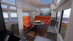 the interior of an rv with orange couches and a small table in front of it