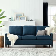 a living room with a blue couch and white rug