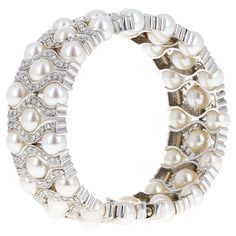 18 karat white gold natural pearl and diamond cuff bangle bracelet. The cuff has slight flexibility allowing you to place it on your wrist with ease and remove it worry free. The cuff has 300 white round brilliant diamonds, in the bracelet weighing an estimated total weight of 5.00 carats. There are 43 natural pearls in the bracelet. The cuff measures 6.5 inches and 0.75 inches wide Pearl And Diamond Bangle, Modern Bangle, Diamond Skull, Modern Bracelets, Bracelet Love, The Bangles, Diamond Bangles Bracelet, Turquoise Bracelet Cuff, Cuff Bangle Bracelet