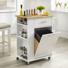 a pink kitchen cart with an open door on the side and some spices in it